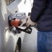a man pumping gas into his car at a gas station
