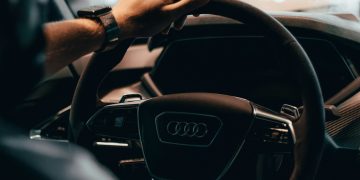 a person driving a car with a steering wheel