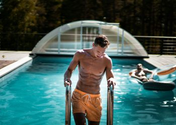 man holding grey steel swimming pool ladder