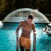 man holding grey steel swimming pool ladder