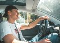 man in white crew neck t-shirt driving car