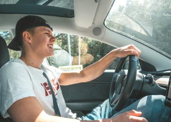 man in white crew neck t-shirt driving car